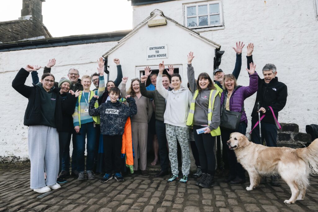 group outside bath house cheering and smiling